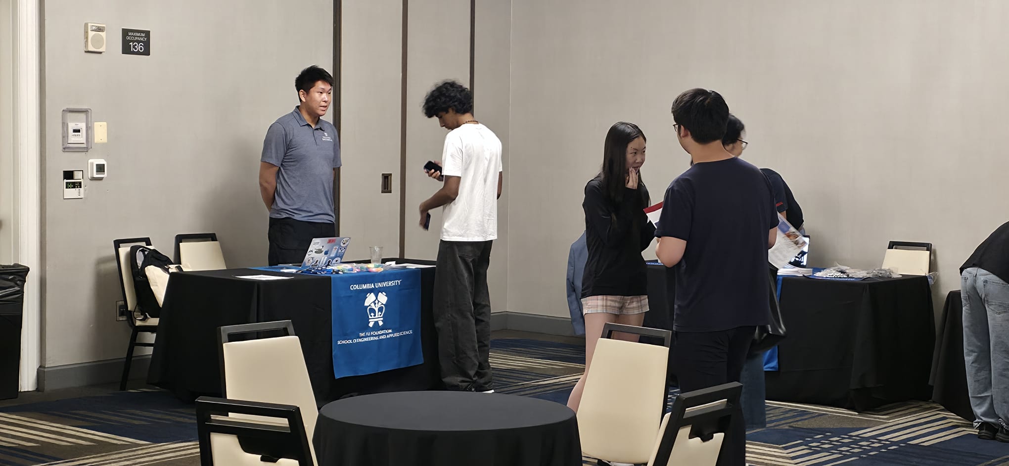 A Columbia University representative speaks with a family at the Fu Foundation School of Engineering table