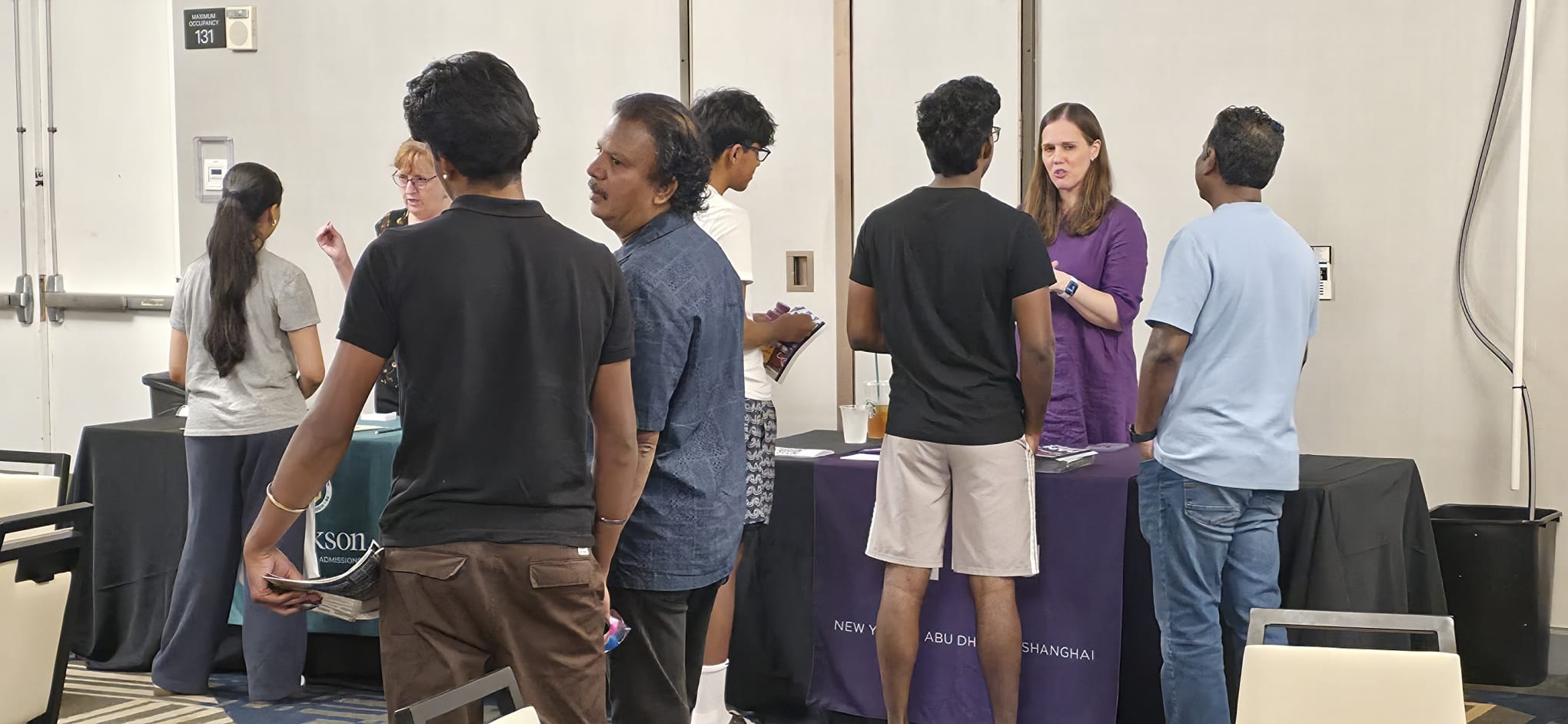 Students and parents speaking with a representative at the NYU table
